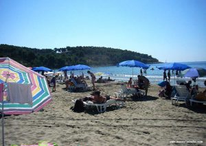 Parasols, sand and beach lounge chairs at Vela Przina